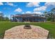 Expansive backyard with a fire pit and screened-in pool area, blending relaxation with outdoor entertainment at 27338 Elkwood Cir, Wesley Chapel, FL 33544