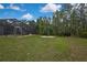 Large backyard featuring a screened-in pool area and fire pit, perfect for outdoor entertaining at 27338 Elkwood Cir, Wesley Chapel, FL 33544