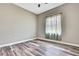 Neutral bedroom with hardwood floors and patterned curtains at 27338 Elkwood Cir, Wesley Chapel, FL 33544