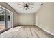 Open bedroom space featuring wood-look floors, a modern ceiling fan, and access to outdoor views through glass doors at 27338 Elkwood Cir, Wesley Chapel, FL 33544
