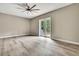 Spacious bedroom with wood-look floors, contemporary ceiling fan, and access to the outdoors via double doors at 27338 Elkwood Cir, Wesley Chapel, FL 33544