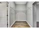 Walk-in closet with hanging metal racks, hard wood floors, white baseboards, and gray walls at 27338 Elkwood Cir, Wesley Chapel, FL 33544