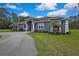 Charming single-story home with a well-manicured lawn, circular driveway, and stone-accented facade at 27338 Elkwood Cir, Wesley Chapel, FL 33544