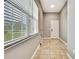Bright hallway with tile flooring, a window providing natural light, and a simple, functional design at 27338 Elkwood Cir, Wesley Chapel, FL 33544