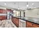 Gourmet kitchen boasts stainless steel appliances, dark cabinetry, pendant lighting, and an open layout at 27338 Elkwood Cir, Wesley Chapel, FL 33544
