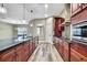 Modern kitchen featuring wood cabinets, stainless steel appliances, granite countertops, and beautiful wood-look flooring at 27338 Elkwood Cir, Wesley Chapel, FL 33544