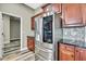 This kitchen includes stainless steel refrigerator, mosaic backsplash, dark cabinets, and wood-look flooring at 27338 Elkwood Cir, Wesley Chapel, FL 33544