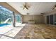 Expansive lanai with stone floors, ceiling fans, and outdoor kitchen area near a pool with slide at 27338 Elkwood Cir, Wesley Chapel, FL 33544