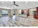 Expansive living room overlooking kitchen boasting wood-look floors, neutral tones, and open concept ideal for entertaining at 27338 Elkwood Cir, Wesley Chapel, FL 33544