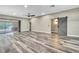 Bright living room features wood-look floors, fan, recessed lighting, and a sliding barn door leading to other living spaces at 27338 Elkwood Cir, Wesley Chapel, FL 33544
