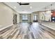 Open concept living space showcasing beautiful wood-look flooring, neutral wall tones, and seamless flow to the kitchen at 27338 Elkwood Cir, Wesley Chapel, FL 33544