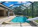 View of the screened pool with a slide, waterfall feature, and beautiful blue sky at 27338 Elkwood Cir, Wesley Chapel, FL 33544