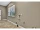 Functional utility room with tile flooring and a window, designed for efficient household tasks and storage at 27338 Elkwood Cir, Wesley Chapel, FL 33544