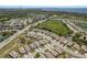 An aerial shot displays homes in a well-planned community, surrounded by trees, near a body of water at 2747 Wood Pointe Dr, Holiday, FL 34691