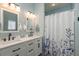 Stylish bathroom with double sinks, white cabinets, modern lighting, and a shower/tub combination at 2747 Wood Pointe Dr, Holiday, FL 34691