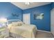 Cozy bedroom with blue walls, a white bed, and a large window at 2747 Wood Pointe Dr, Holiday, FL 34691
