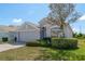 Charming single-story home featuring a well-maintained front lawn, mature landscaping, and a two-car garage at 2747 Wood Pointe Dr, Holiday, FL 34691