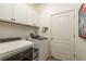 Clean laundry room with new washer and dryer, upper cabinets, and a back door at 2747 Wood Pointe Dr, Holiday, FL 34691