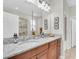 Bathroom with double sinks, granite countertops, modern fixtures, and decorative wall art at 3095 Riders Pass, Odessa, FL 33556