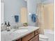 Bathroom with granite countertop vanity, framed mirror, and shower with a patterned curtain at 3095 Riders Pass, Odessa, FL 33556