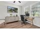 Functional home office with computer desk, rolling chair, mounted TV, and a bright window for natural light at 3095 Riders Pass, Odessa, FL 33556