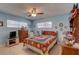 Bright bedroom with light blue walls, two windows, ceiling fan, and hardwood furniture at 3104 W Powhatan Ave, Tampa, FL 33614