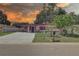 Charming pink one-story home featuring a covered carport, manicured lawn, and mature landscaping at 3104 W Powhatan Ave, Tampa, FL 33614