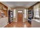 Inviting foyer with wood-look tile flooring, built-in shelving, and a solid wood front door at 3104 W Powhatan Ave, Tampa, FL 33614
