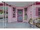 Charming front porch featuring pink walls, decorative windows, and a secure metal door at 3104 W Powhatan Ave, Tampa, FL 33614