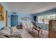 Cozy living room showcases blue walls, plush sofas, area rug, and natural light from a large window at 3104 W Powhatan Ave, Tampa, FL 33614