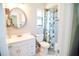 Bathroom features an updated white vanity and a shower with a floral curtain at 3139 W Varn Ave, Tampa, FL 33611