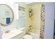 Cozy bathroom featuring a tub with a colorful shower curtain and round mirror at 3139 W Varn Ave, Tampa, FL 33611