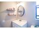 This well-lit bathroom features wall shelves and a vanity with an oval mirror at 3139 W Varn Ave, Tampa, FL 33611