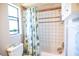The bathtub and shower have ceramic tiling and a floral shower curtain at 3139 W Varn Ave, Tampa, FL 33611