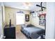 Bedroom featuring a cozy bed, a baseball themed wall design, and a window for natural light at 3139 W Varn Ave, Tampa, FL 33611