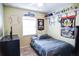 Bedroom featuring a cozy bed, a baseball themed wall design, and a window for natural light at 3139 W Varn Ave, Tampa, FL 33611
