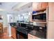 Kitchen featuring dark countertops, a microwave, and wooden cabinets at 3139 W Varn Ave, Tampa, FL 33611