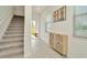 Bright entryway featuring tile floors, staircase, and stylish storage cabinet at 3228 Bryant Park Dr, New Port Richey, FL 34655