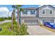 Charming townhome featuring a two-car garage, manicured lawn, and decorative stone accents at 3228 Bryant Park Dr, New Port Richey, FL 34655