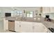 Well-designed kitchen with granite countertops, stainless steel appliances, and white cabinets overlooking the living area at 3228 Bryant Park Dr, New Port Richey, FL 34655