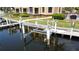 Modern boat lift on the water with adjacent dock and nearby condos surrounded by lush green landscaping at 3334 Purple Martin Dr # 212, Punta Gorda, FL 33950