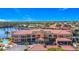 Expansive exterior shot of the red-roofed Grand Bay building with lush landscaping, a fountain, and ample parking at 3334 Purple Martin Dr # 212, Punta Gorda, FL 33950