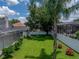 An overview of the spacious, manicured backyard with mature trees and a screened enclosure at 3909 Valrico Grove Dr, Valrico, FL 33594