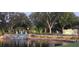 Valrico Grove entrance showcasing lush landscaping, a pond, and a waterfall feature that reflects the evening light at 3909 Valrico Grove Dr, Valrico, FL 33594