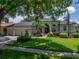 Traditional-style home featuring a well-manicured lawn, mature trees, and a spacious three-car garage at 3909 Valrico Grove Dr, Valrico, FL 33594