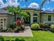 Charming single-story home boasts lush landscaping and a welcoming entrance with a dark-colored, double-door entry at 3909 Valrico Grove Dr, Valrico, FL 33594