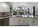 Modern kitchen with white cabinets, granite countertops, and views into the living room at 3909 Valrico Grove Dr, Valrico, FL 33594