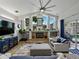 Bright living room with a fireplace, vaulted ceilings, and large windows overlooking the outdoor swimming pool area at 3909 Valrico Grove Dr, Valrico, FL 33594