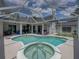 Backyard view of the pool and spa inside a screened enclosure at 3909 Valrico Grove Dr, Valrico, FL 33594