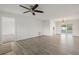 Spacious living room featuring wood-look flooring, ceiling fan, and sliding glass doors to the outdoor area at 4230 Indianapolis Ne St, St Petersburg, FL 33703
